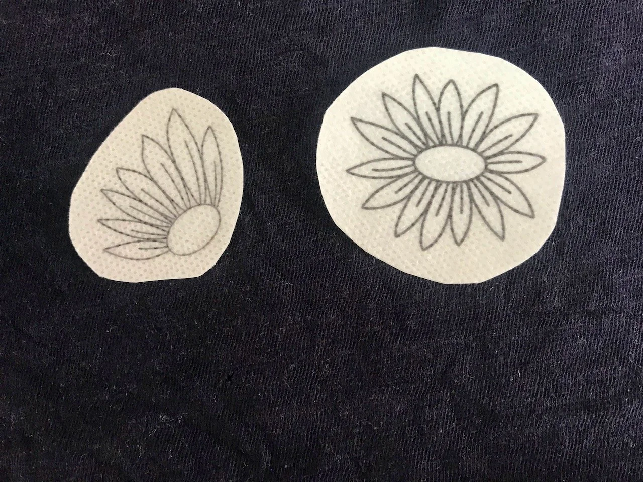Two sunflower patches stuck on a navy blue t shirt - covering holes