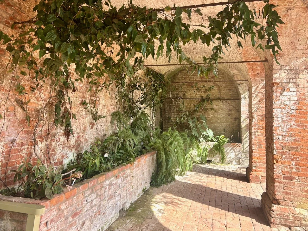 Inside the brick arches and the raised brick planters are filled with ferns and greenery