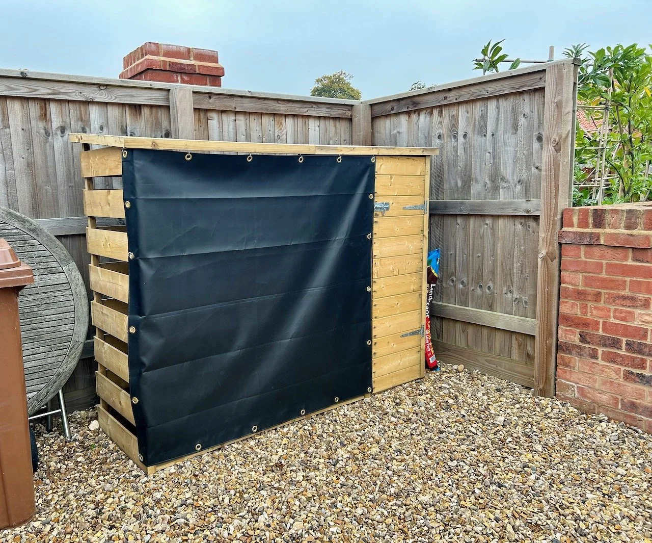 The log store now with a tarpaulin covering the logs