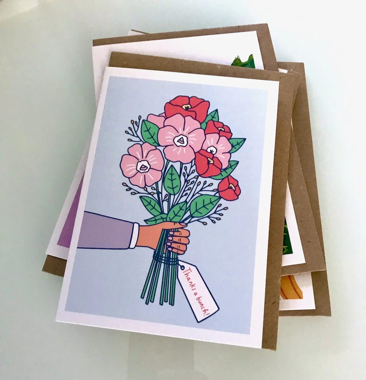 AN ARM HELD OUT HOLDING A BUNCH OF FLOWERS WITH 'THANKS A BUNCH' LABEL