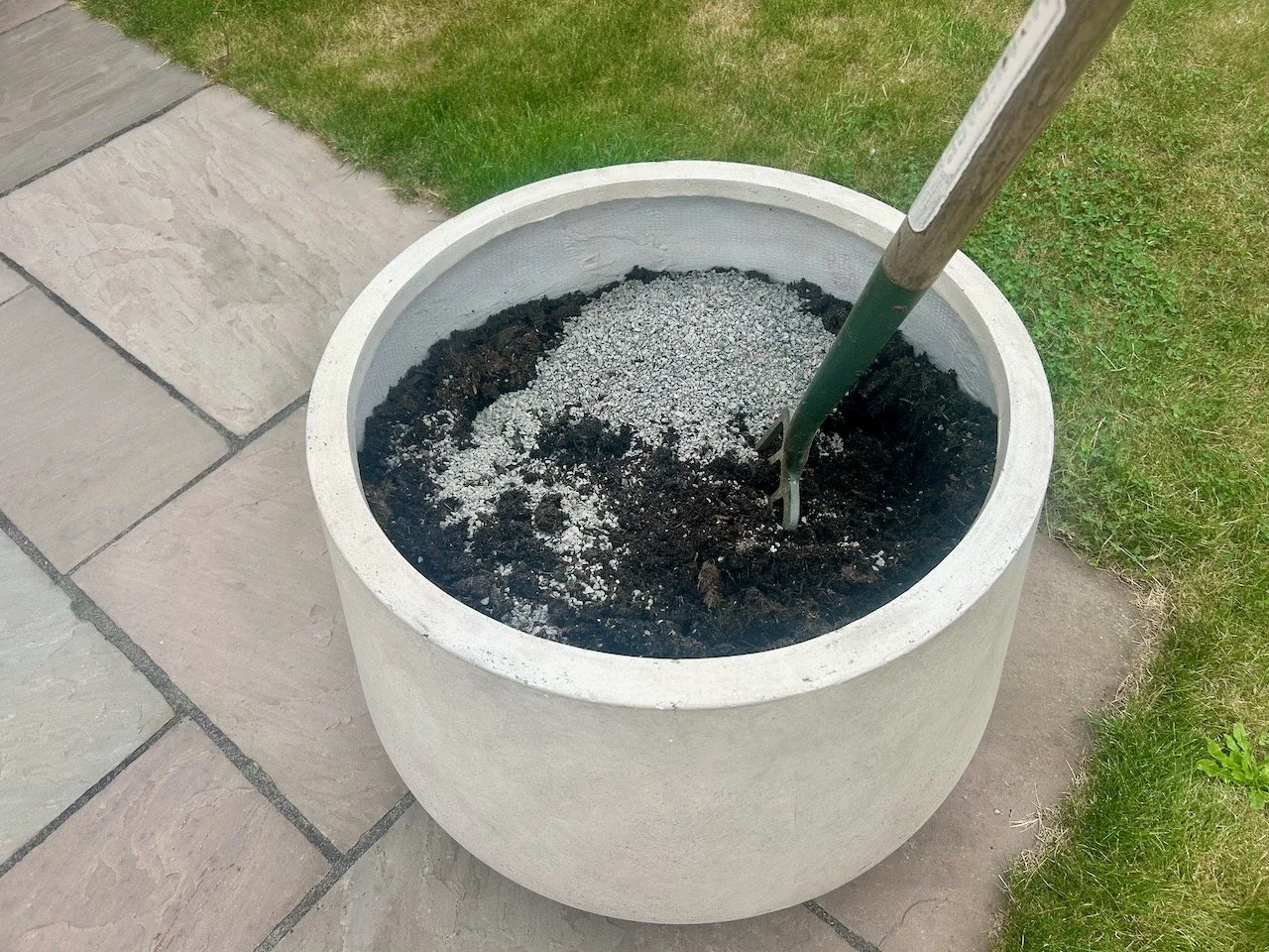 The large pot partly filled with compost and horticultural grit - with a garden fork stuck in the contents