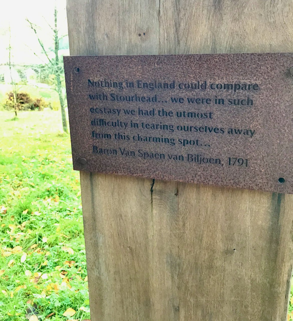 a quote punched into an iron plaque mounted on a wooden post