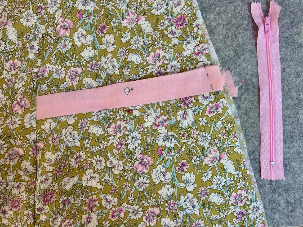 The other pocket with the pink trim basted in place and the pink zip alongside