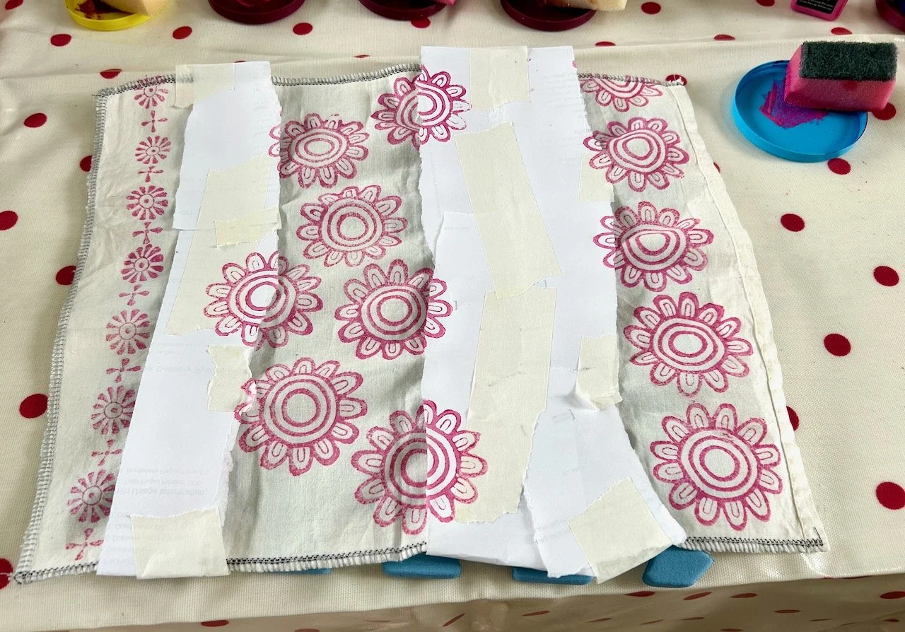 Using torn paper to mask my already completed embroidery before printing flower shapes in the blank spaces