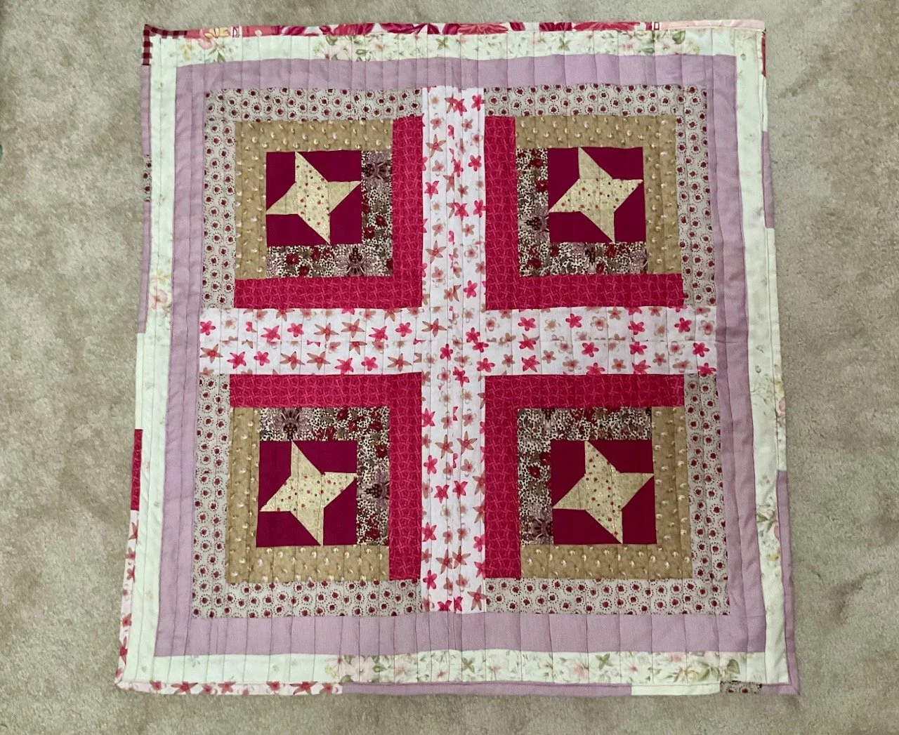 The finished quilt with straight line quilting in burgundy thread and a scrappy binding