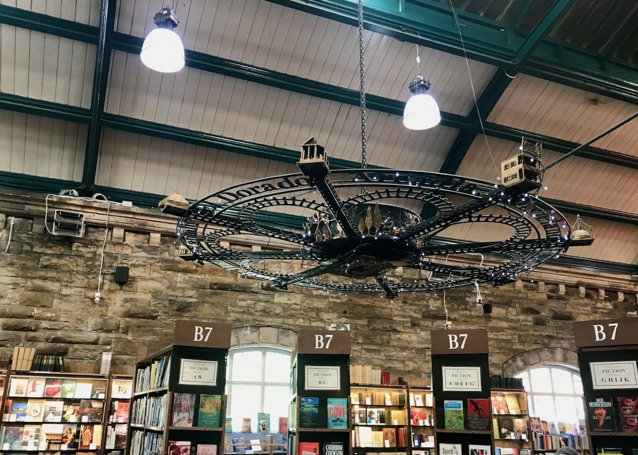 Among the rows of books in the old train station - with a train track light fitting above