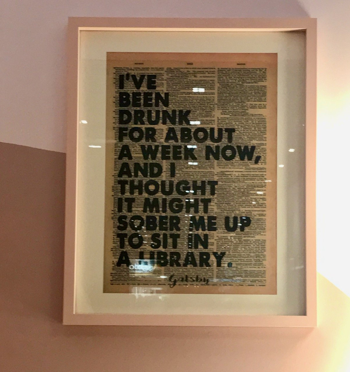 The artwork on the painted wall - print on newspaper print saying "I've been drunk for about a week now, and I thought it might sober me up to sit in a library" from Gatsby