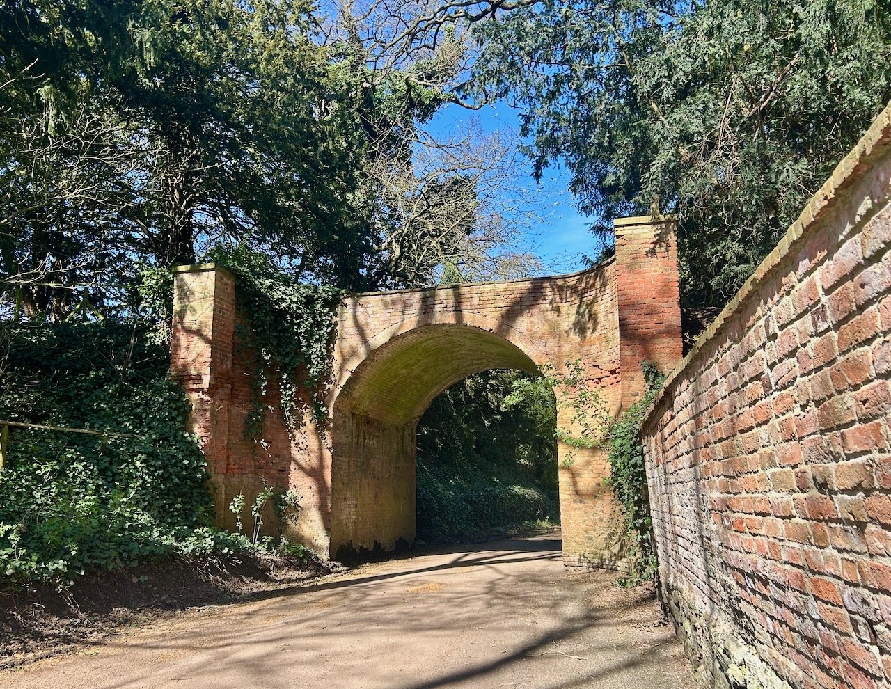 A brick archway on Church Lane in the dappled sunshine