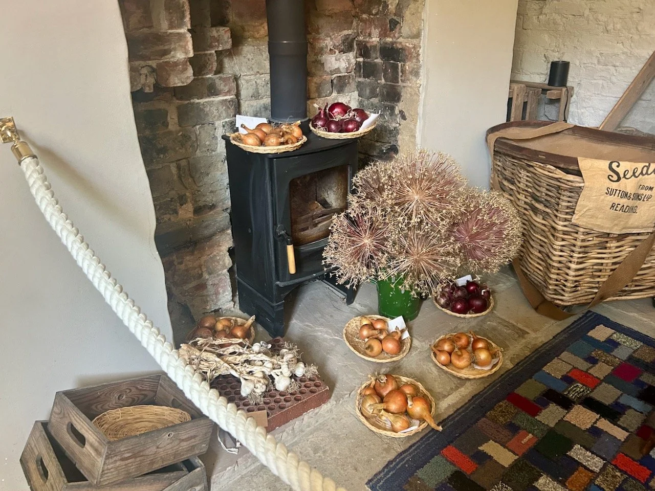The log burner adorned with onions, garlic and seed heads drying
