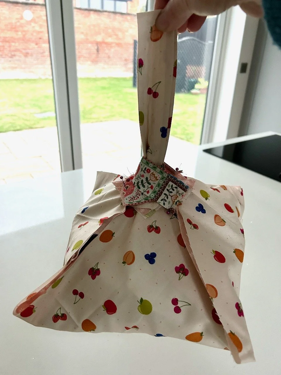 It's pinned together with handles and is holding up with an empty cake tin inside