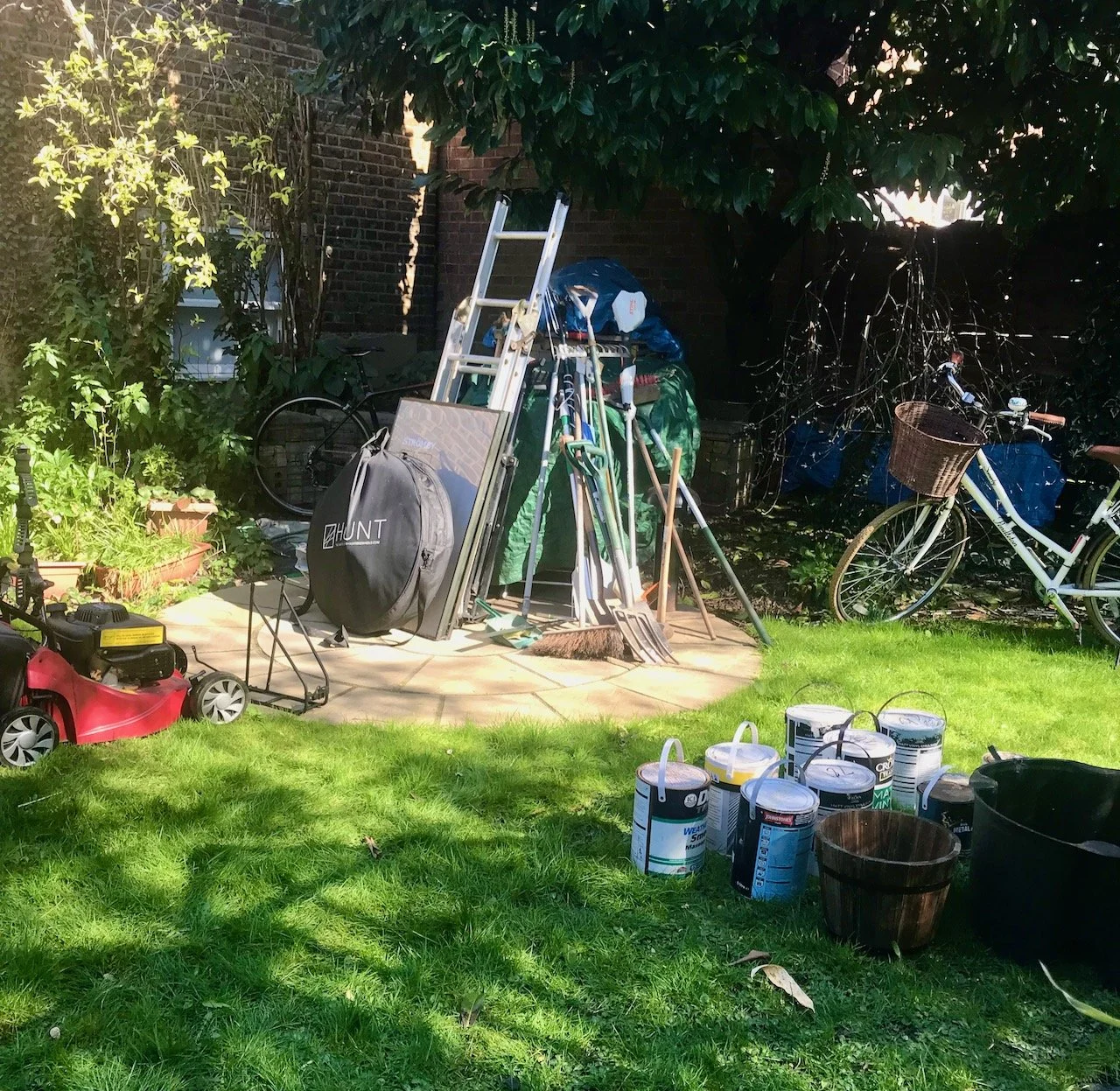 Larger items, bikes, tools, ladders and the lawnmower are stored temporarily on the circle and against the still covered patio table
