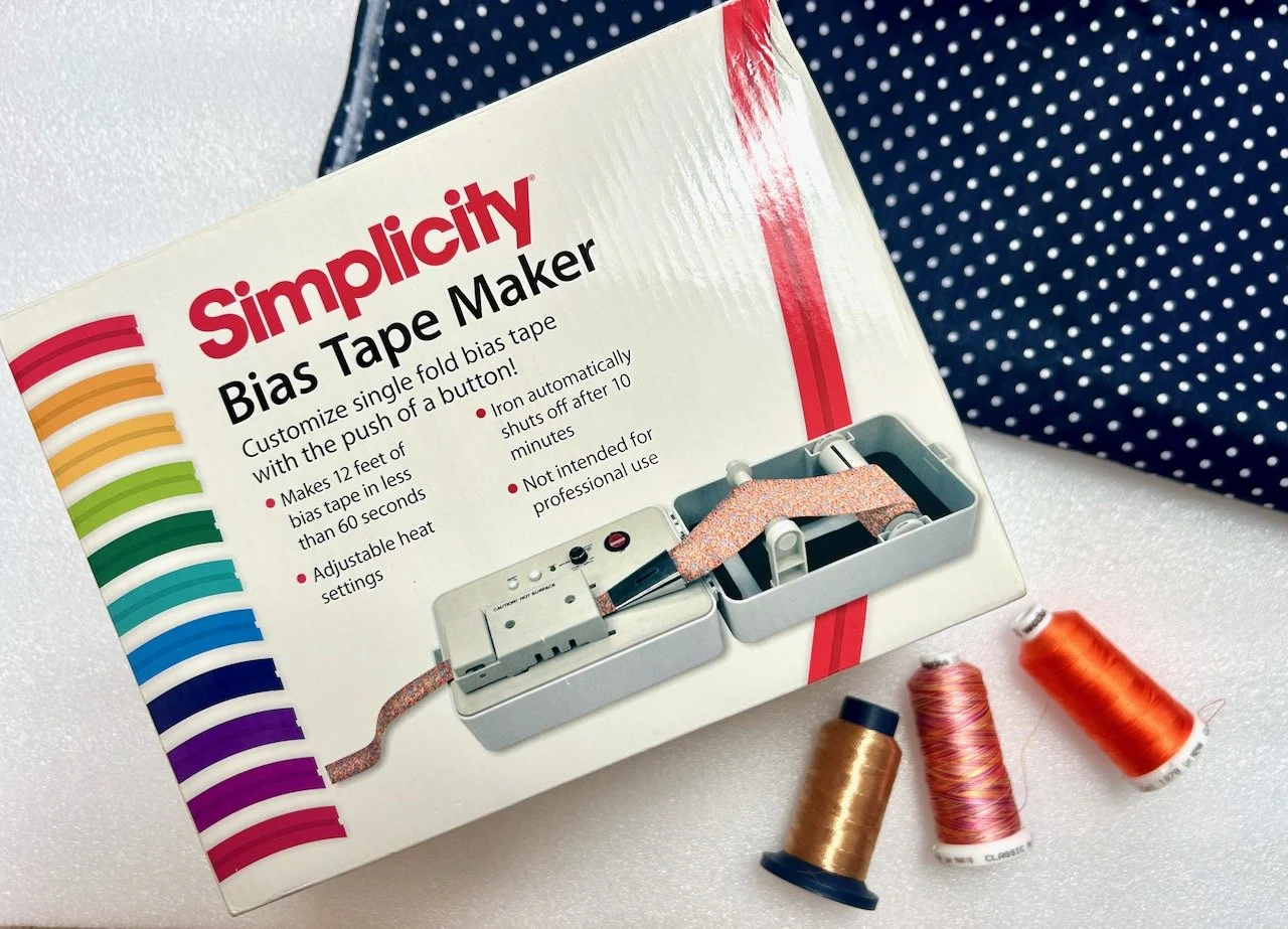 Bias tape maker, threads and some blue/white dotty cotton