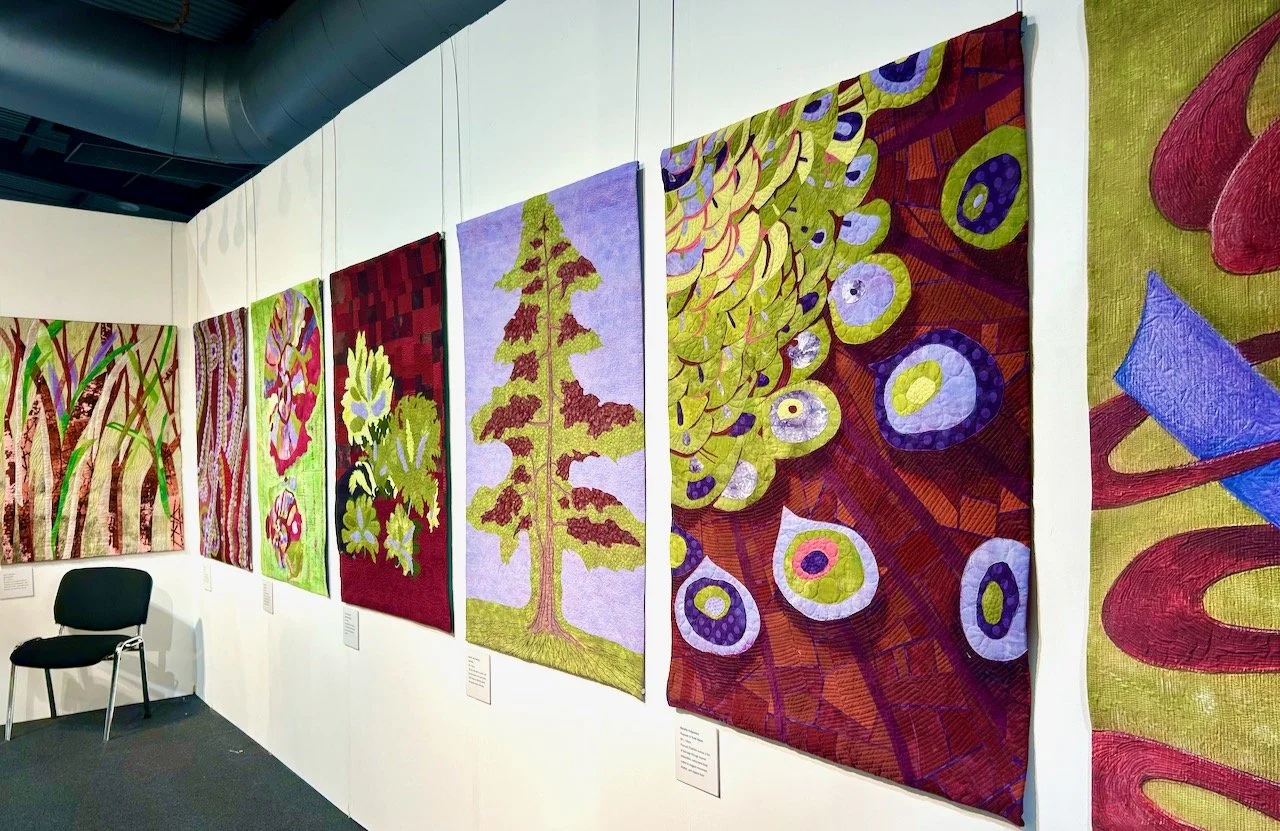 Looking across the quilts in one of the series in the Colour Relationships gallery by Colorminds at the Festival of Quilts 2025