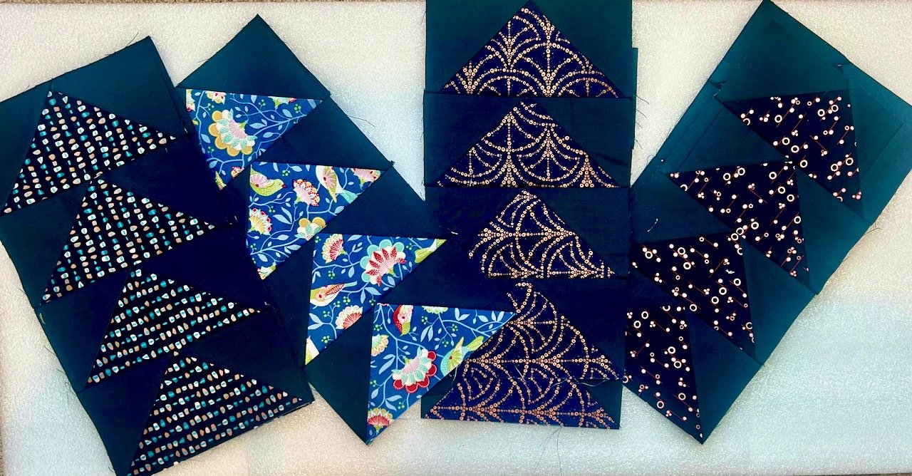 Some of the already completed blocks of Flying Geese - sewn together in fours of the same fabric
