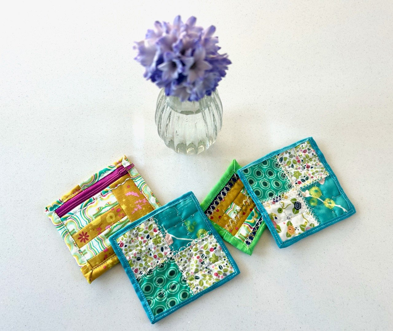 A small pouch with a pink zip, two turquoise bound mats - and the teeny tiny mat