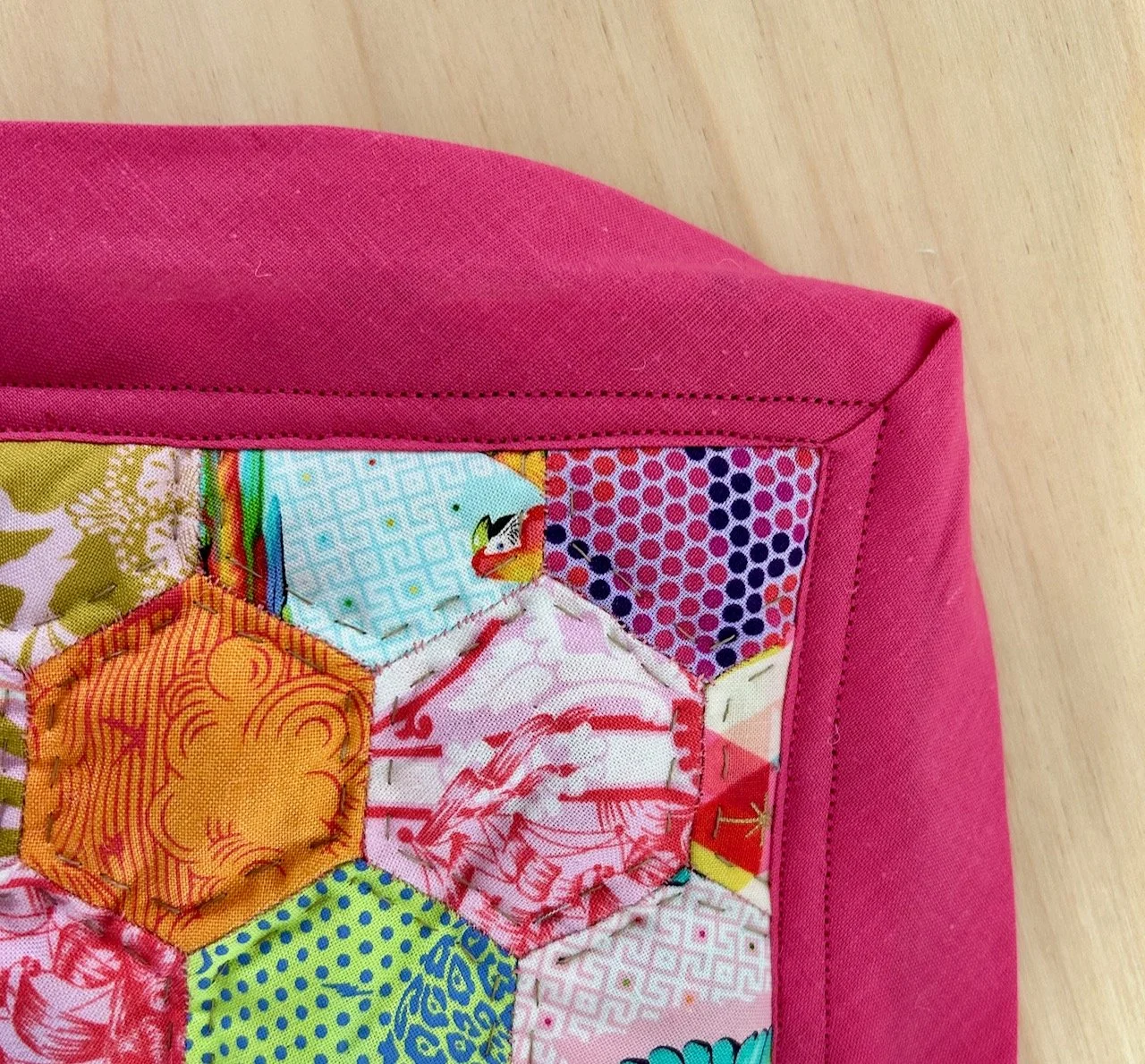 Bias binding and a mitred corner with two rows of machine sewing attaching it to the front of the mat