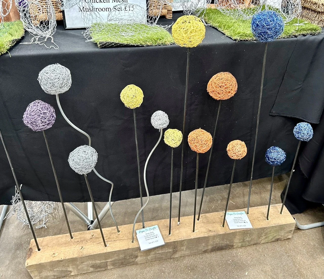 spheres made from chicken wire mounted on poles at varying heights