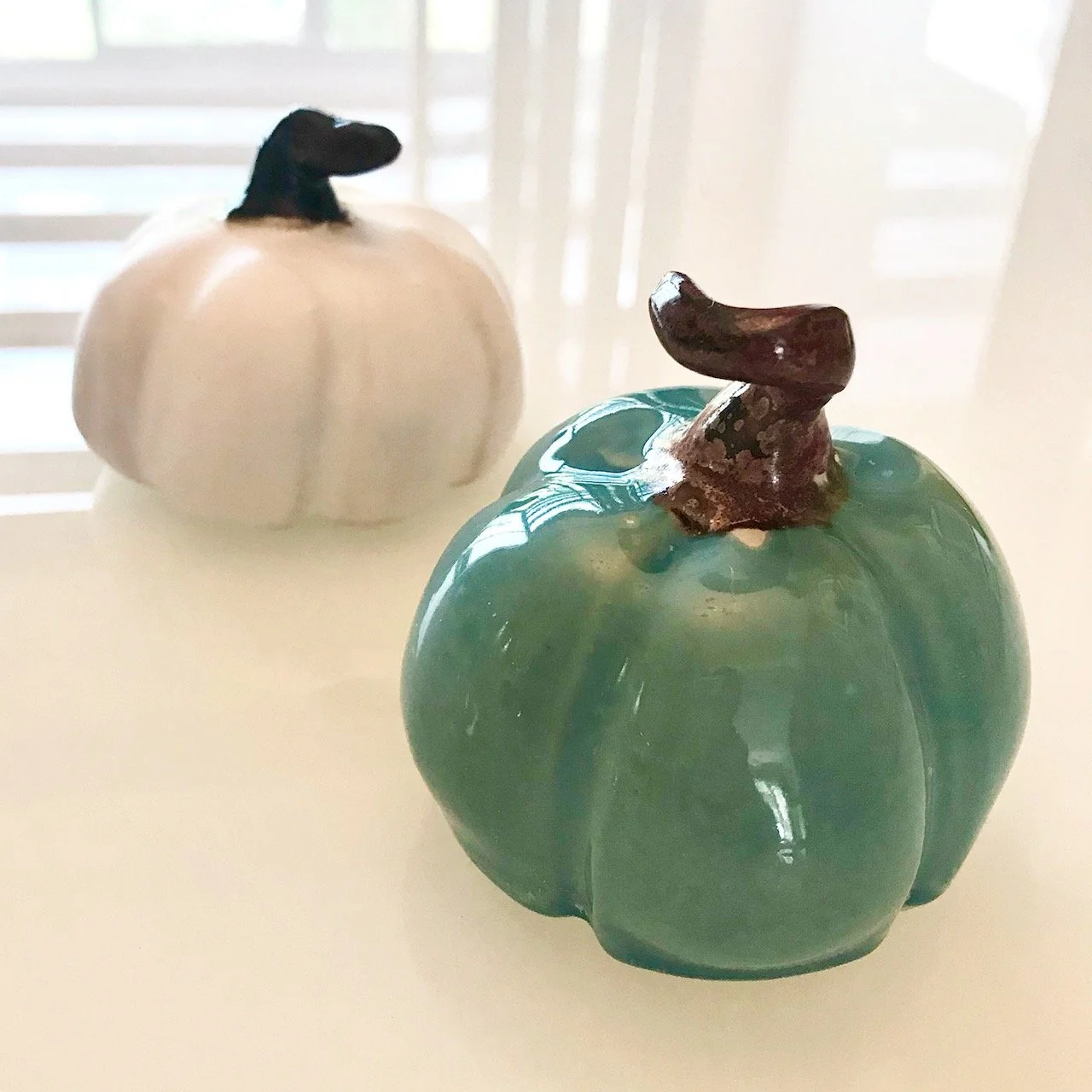 two small ceramic pumpkins on my table - one white, one duck egg blue (naturally!)