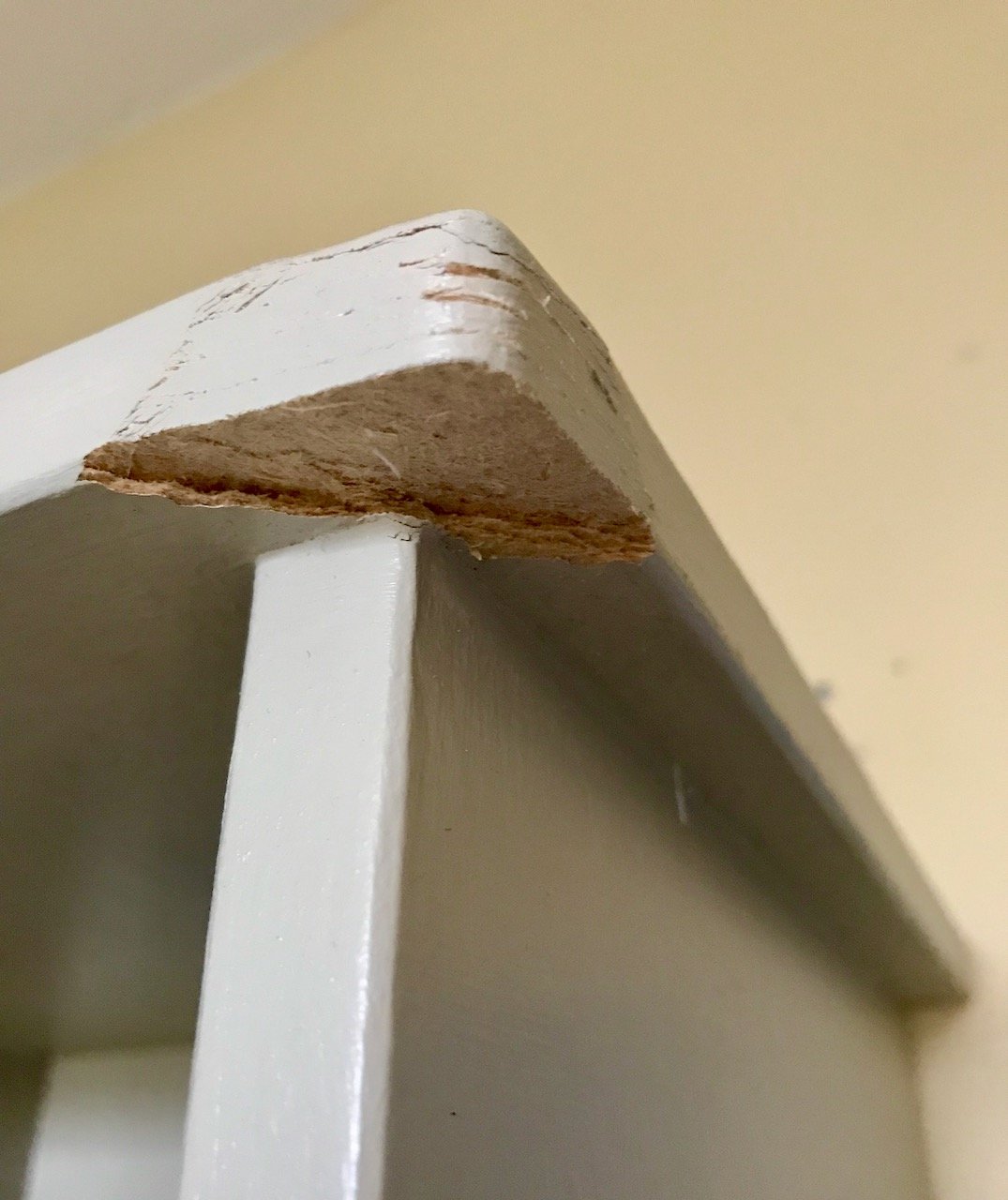A close up of the front top corner which is showing some wear and has a missing triangular section