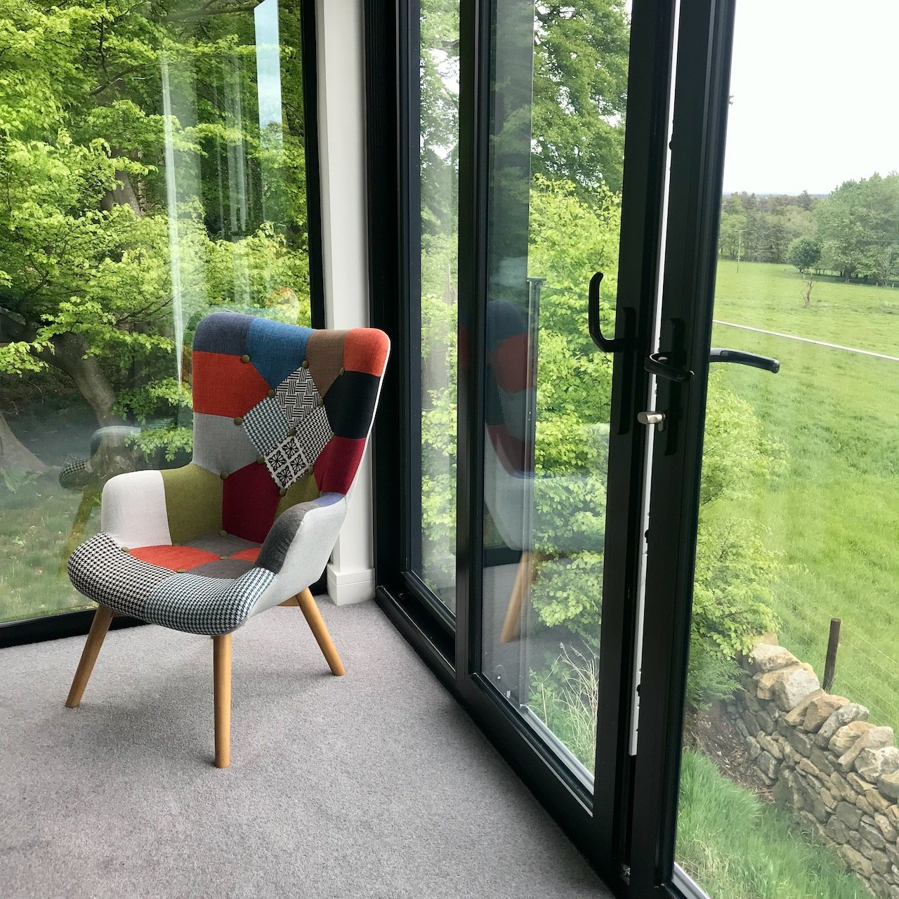 A patchwork arm chair in the corner of the bedroom in the treehouse