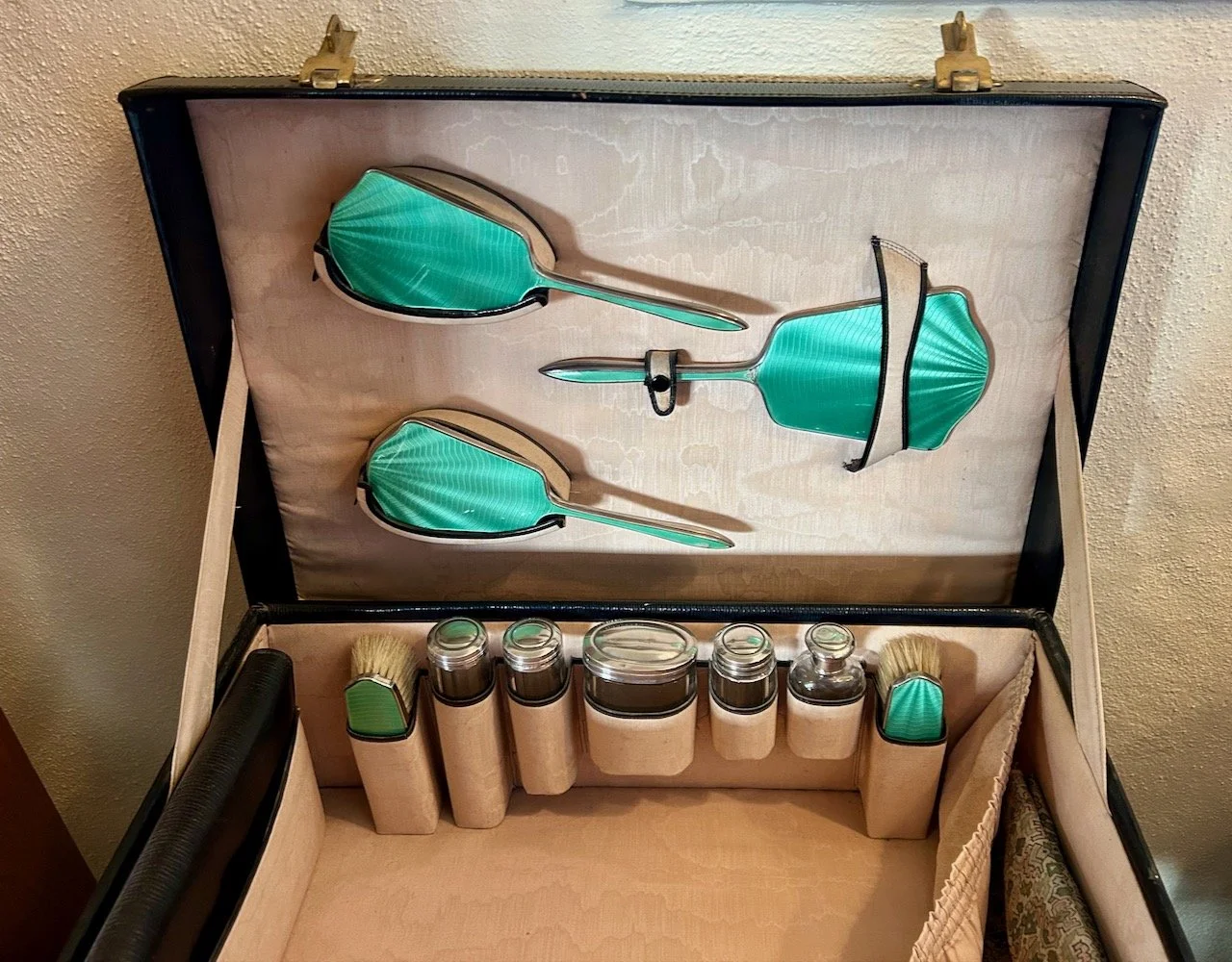An emerald coloured vanity set in a travel case