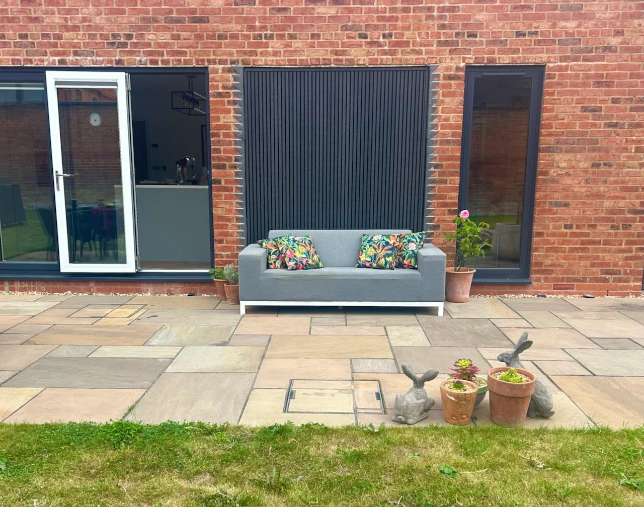 the outdoor sofa, softened with plants - in pots alongside it
