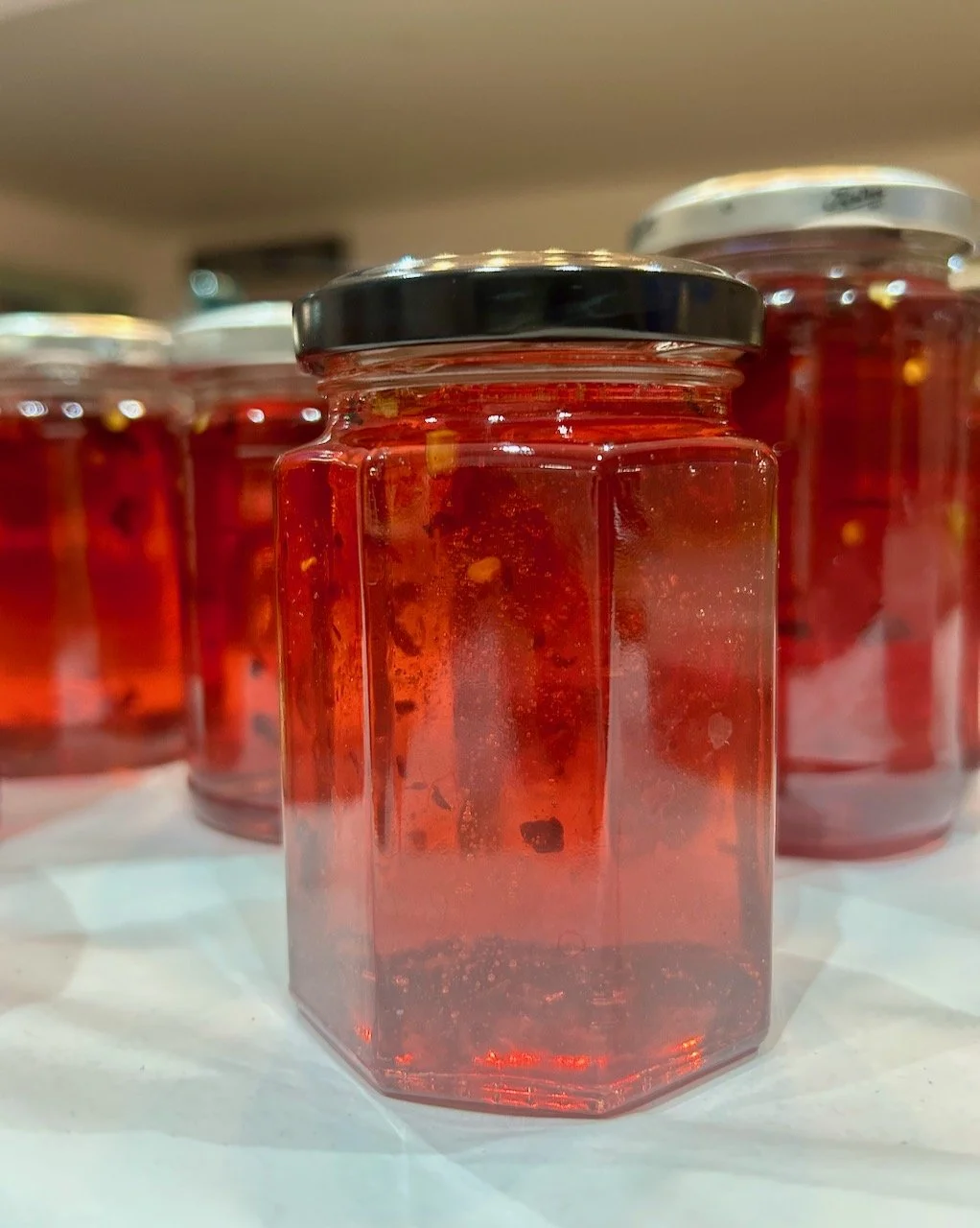 Some of the jars of my newly made chilli jelly - red in colour with flecks of chilli