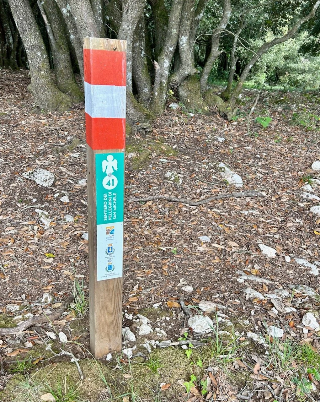 A red and white striped waymarker post