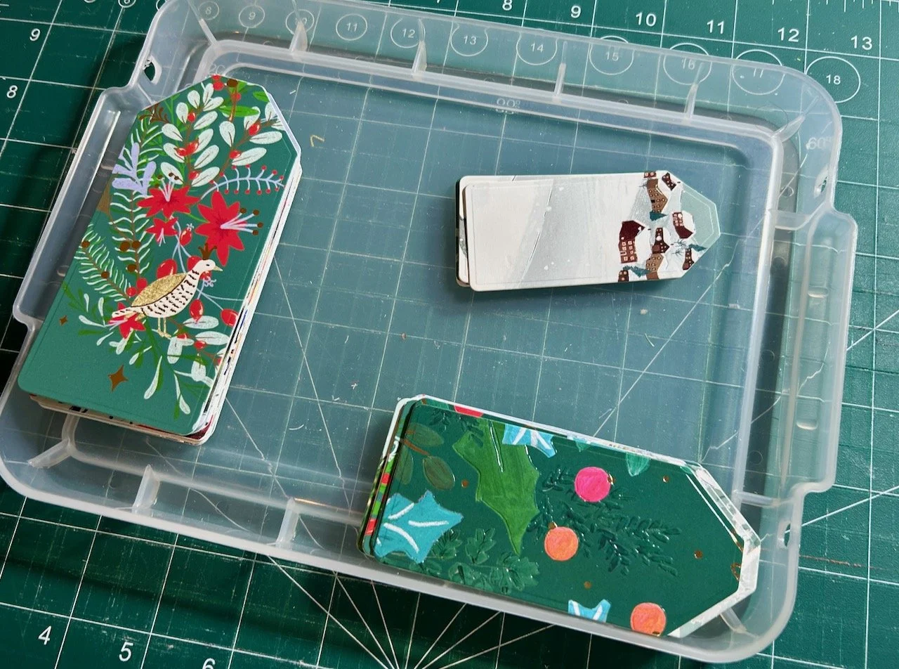 A stack of three different sized tags ready for the next stage