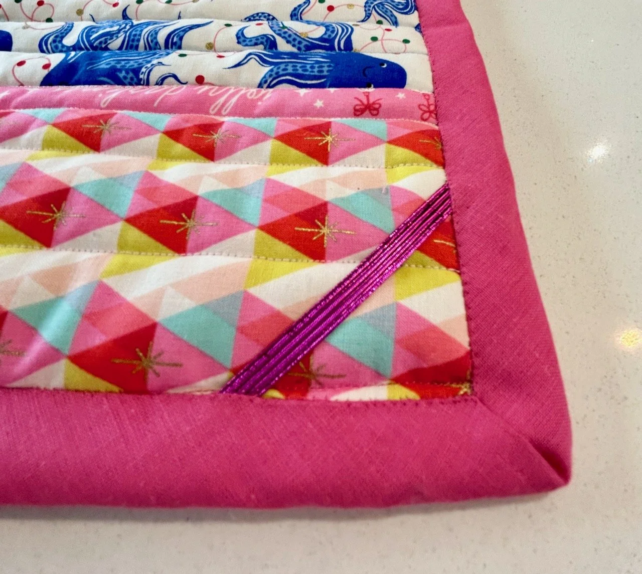 The rear side of the mat with elastic across the corner and hand stitched binding