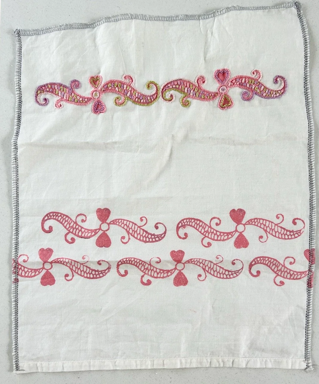 The top row of swirls is now embroidered in pale pinks, cream, lilac and pistachio.  The two bottom rows remain untouched