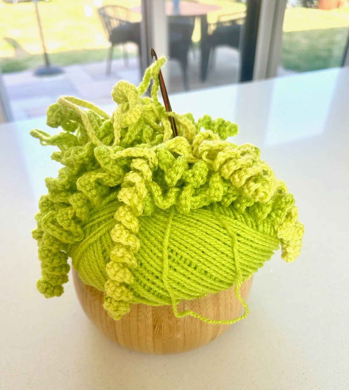 My lime green crochet project in my wooden crochet bowl
