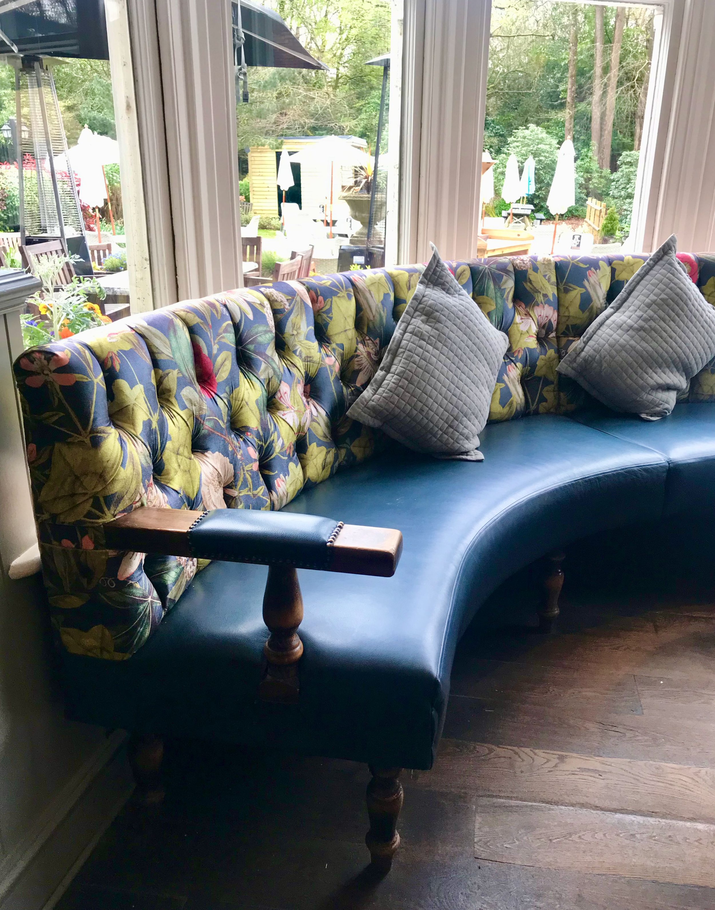 A leather seat and patterned buttoned back curved seat in the bar area