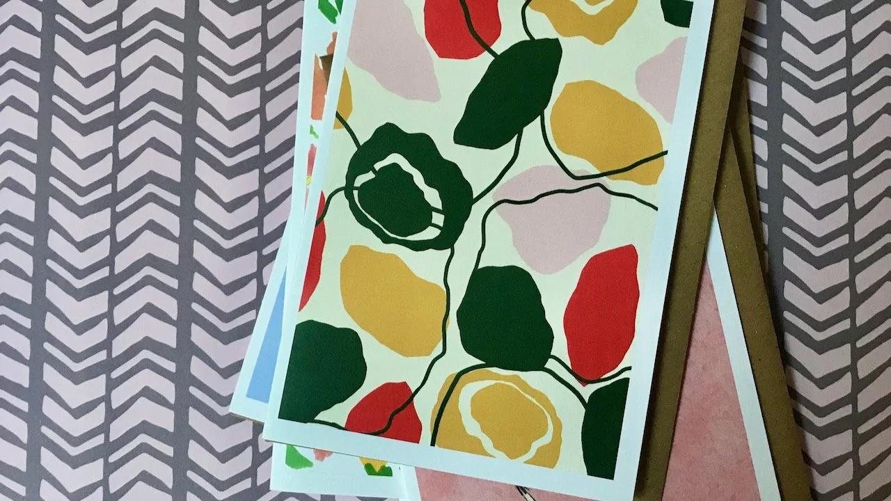 pastel pink, yellow, red and green splodges creating a flowerlike patter on a cream background