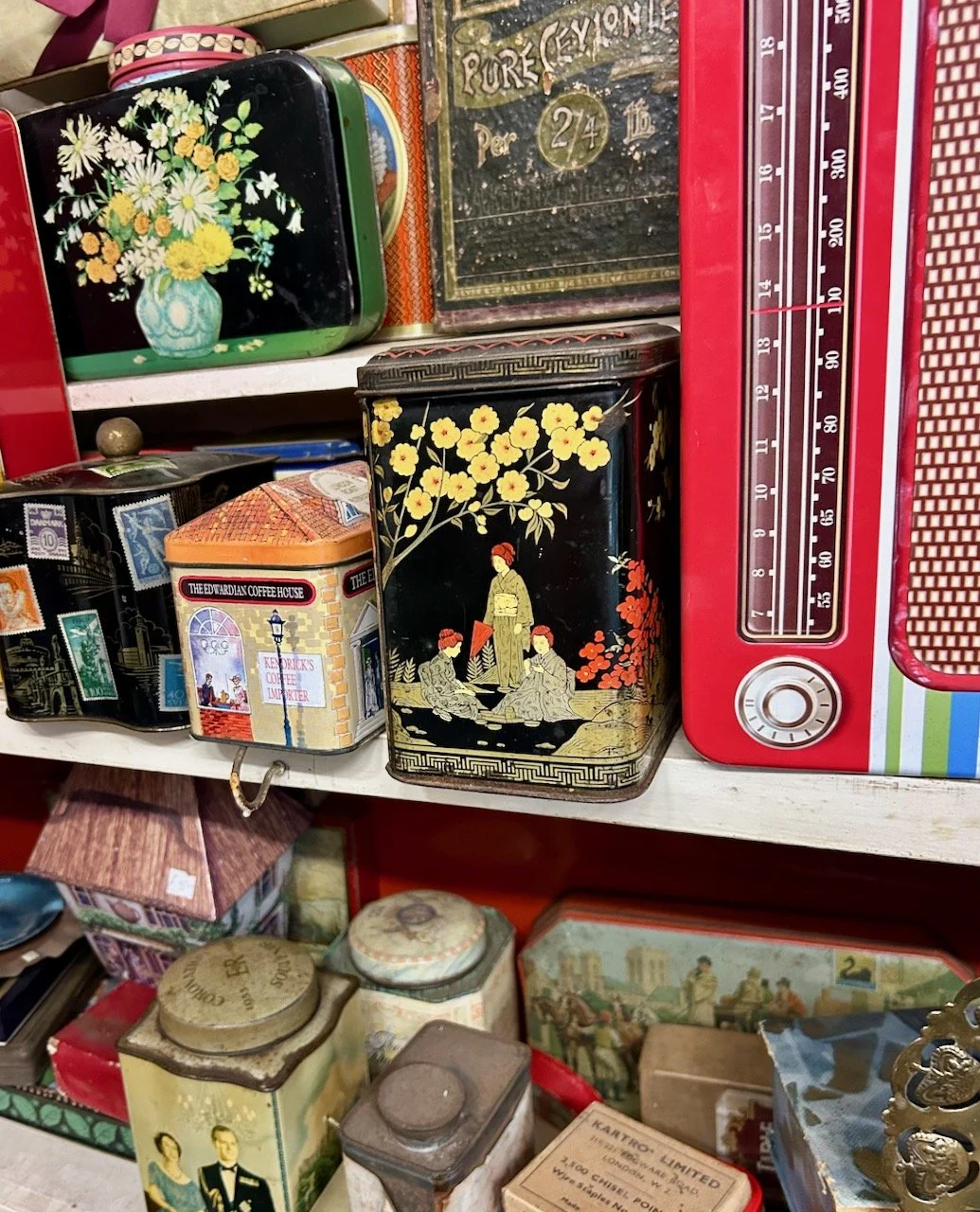 Three shelves of various aged tins - in the centre is a black chinoiserie type tin, which reminded me of one I have