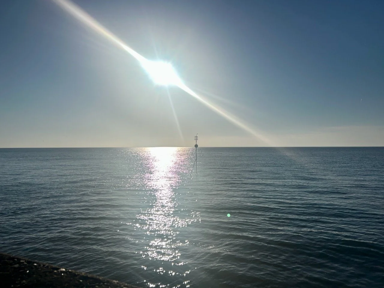 Looking out over the sea wall at Hunstanton - the tide's in - to the sun in the distance
