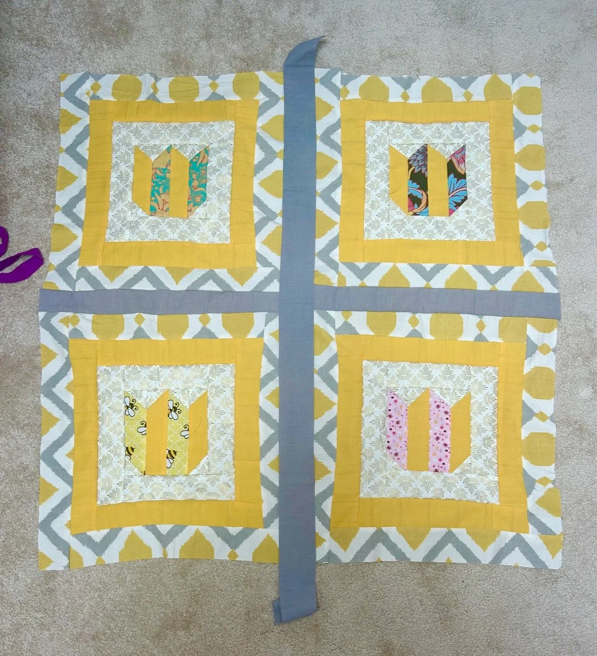 Trying out some plain grey sashing between the four blocks