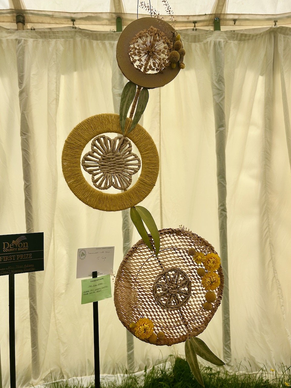 THREE CIRCLES STRUNG TOGETHER DECORATED WITH TWINE AND TONING FLOWERS
