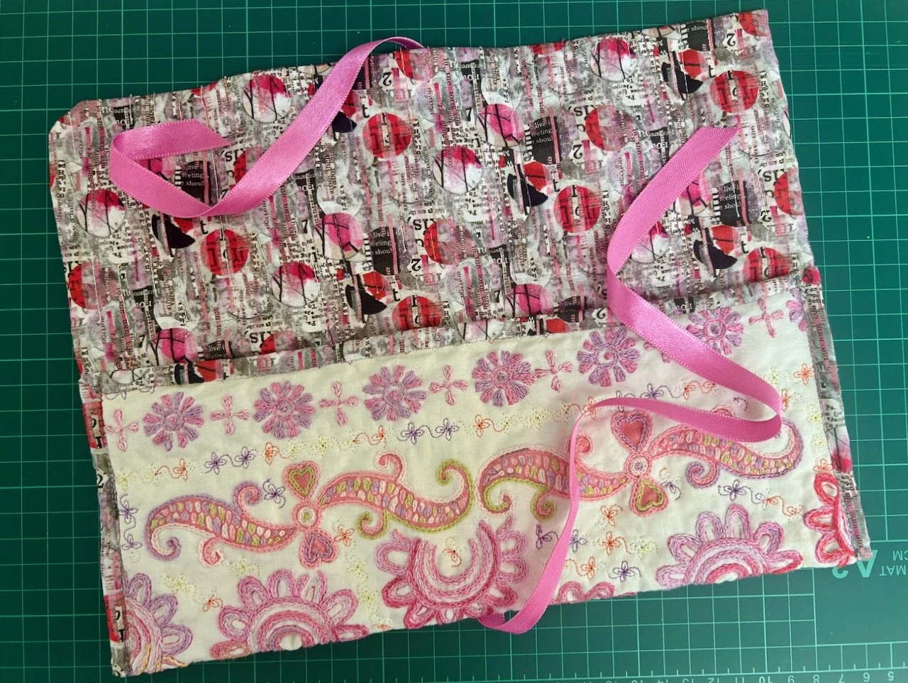 The pink ribbon's attached to the back, and will be 'flowing' when the pouch is opened