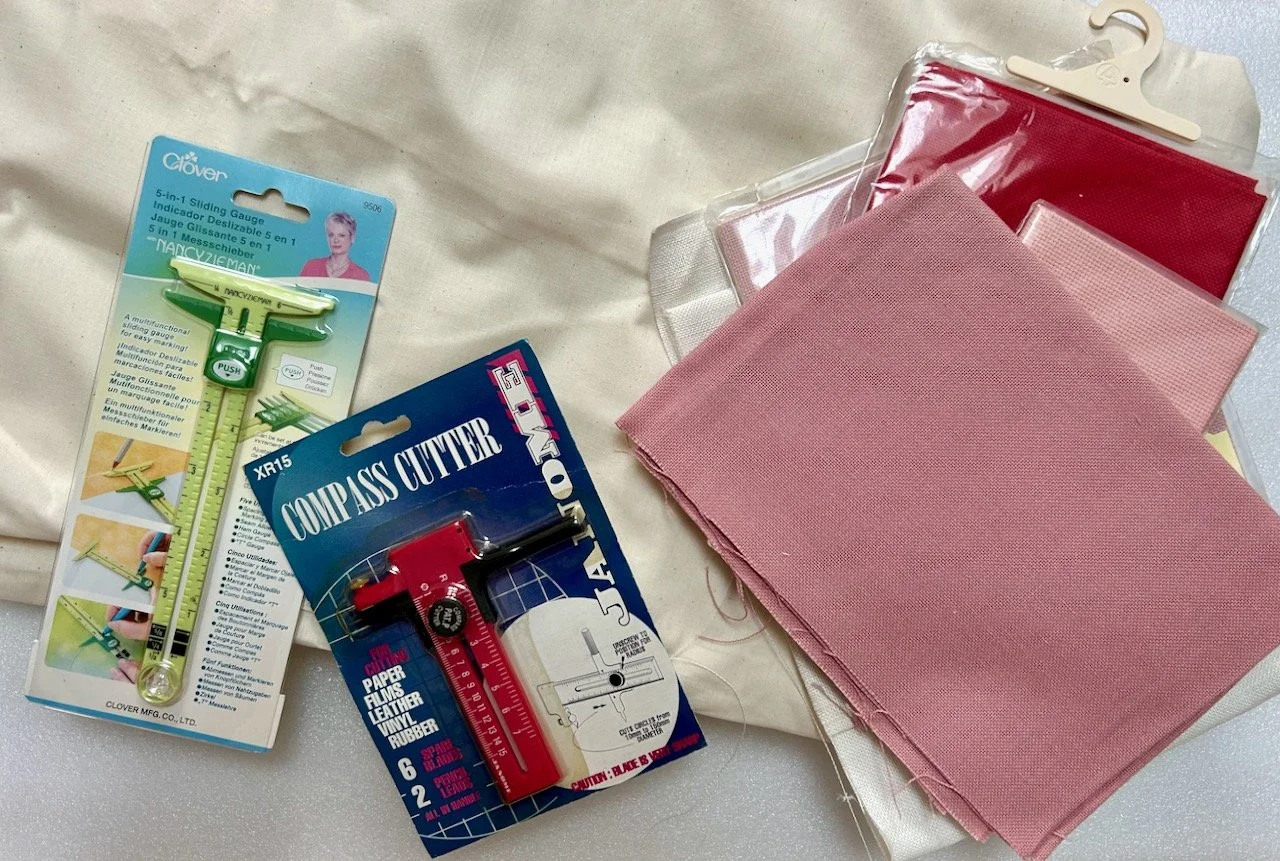 Calico at the back, hardanger and aida fabrics on the right and a couple of useful looking gadgets