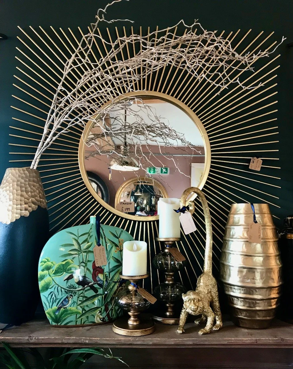 A mantelpiece setting with a mirror, candlesticks and vases, plus a brass monkey