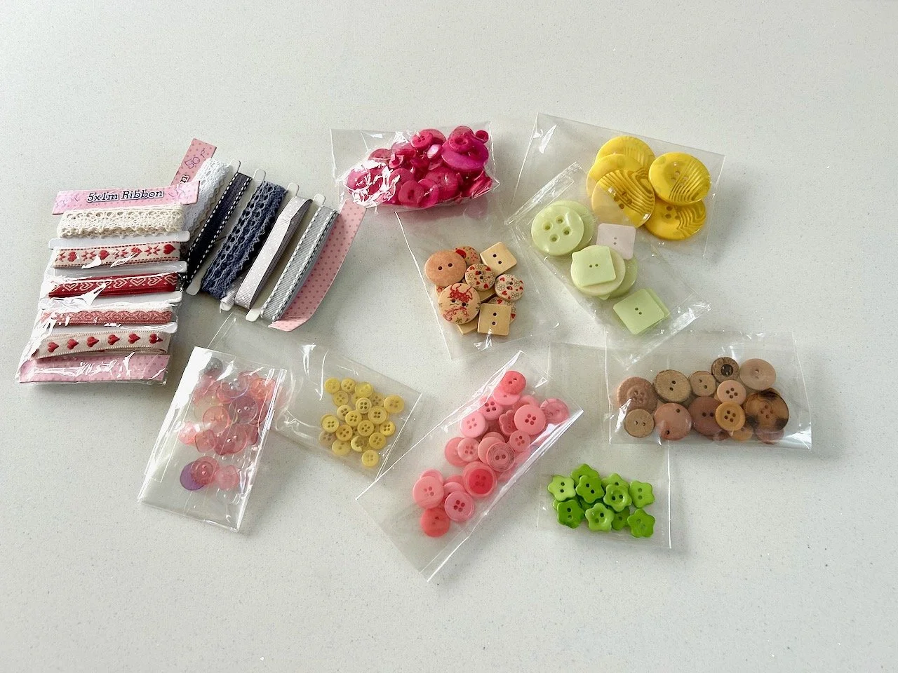 Nine packs of variously shaped and coloured vintage buttons and two cards of ribbons