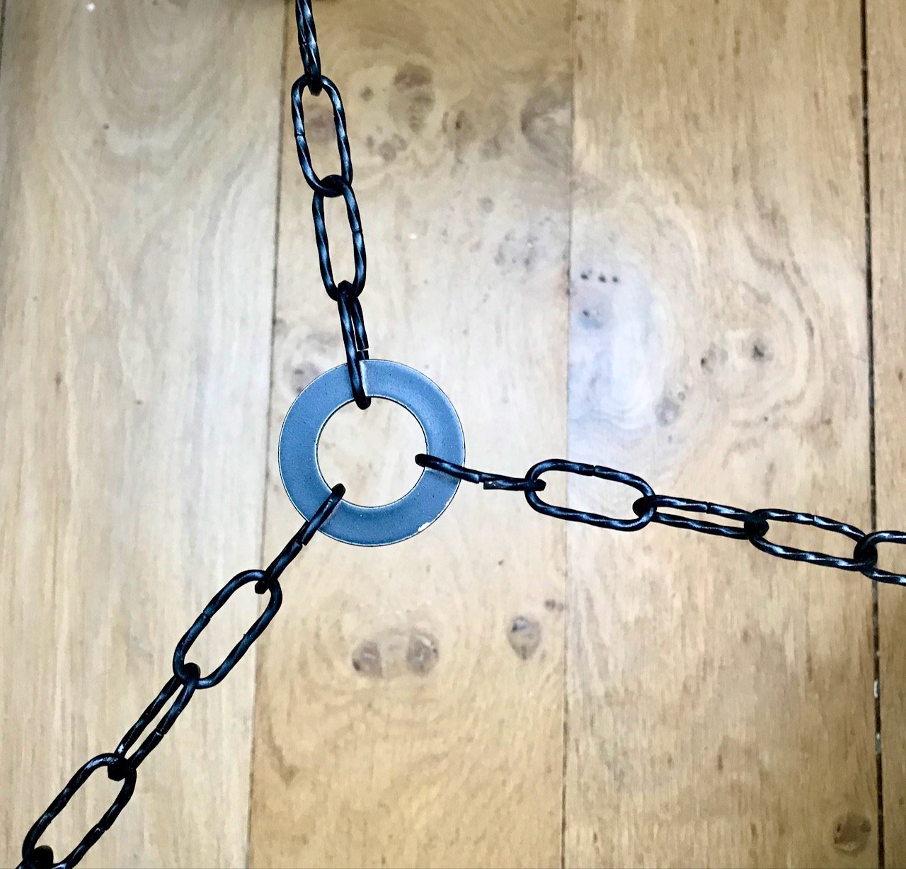 Looking down at the chain and the central ring of the tripod legs
