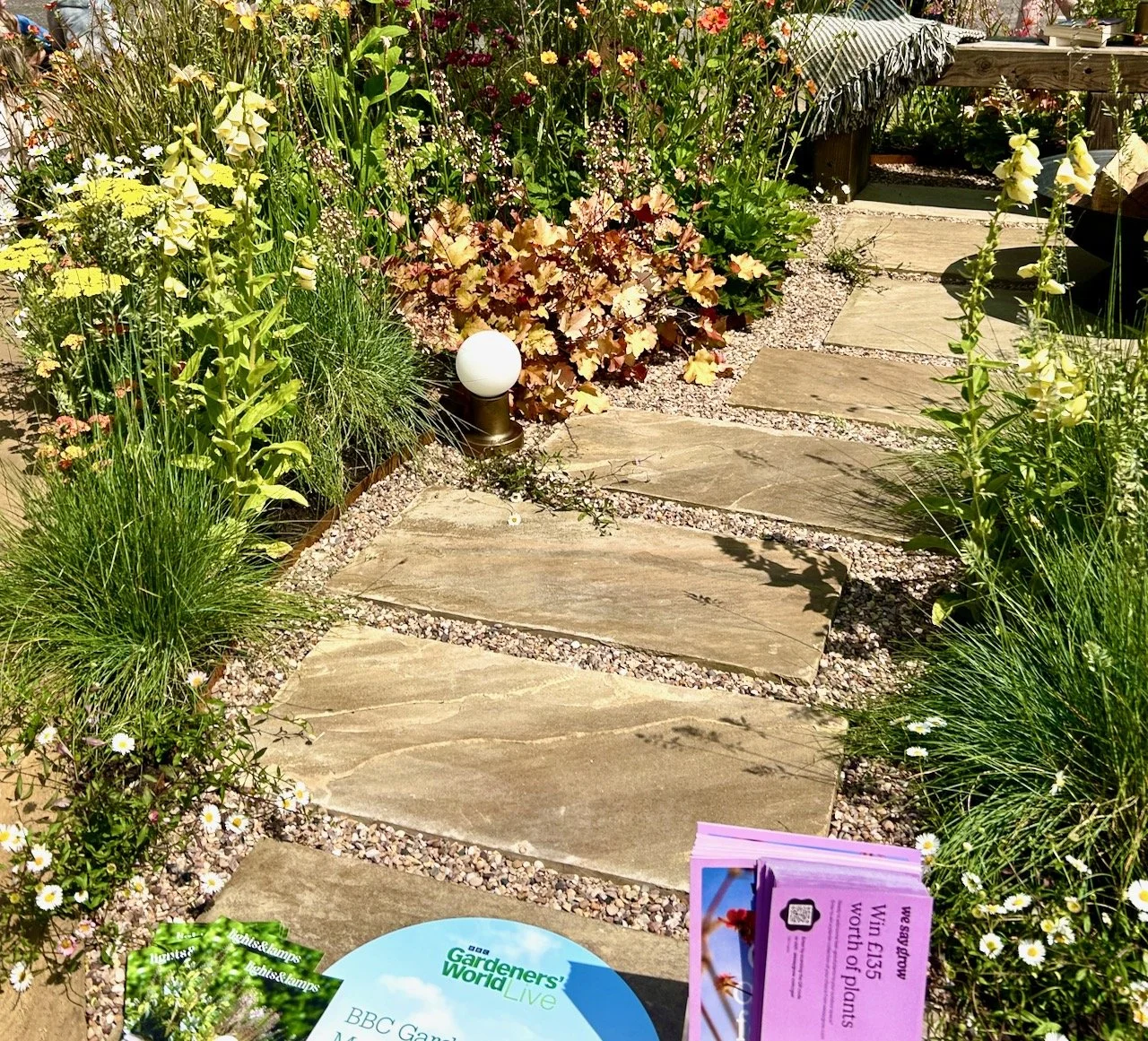 A meandering path edged with gravel through the border