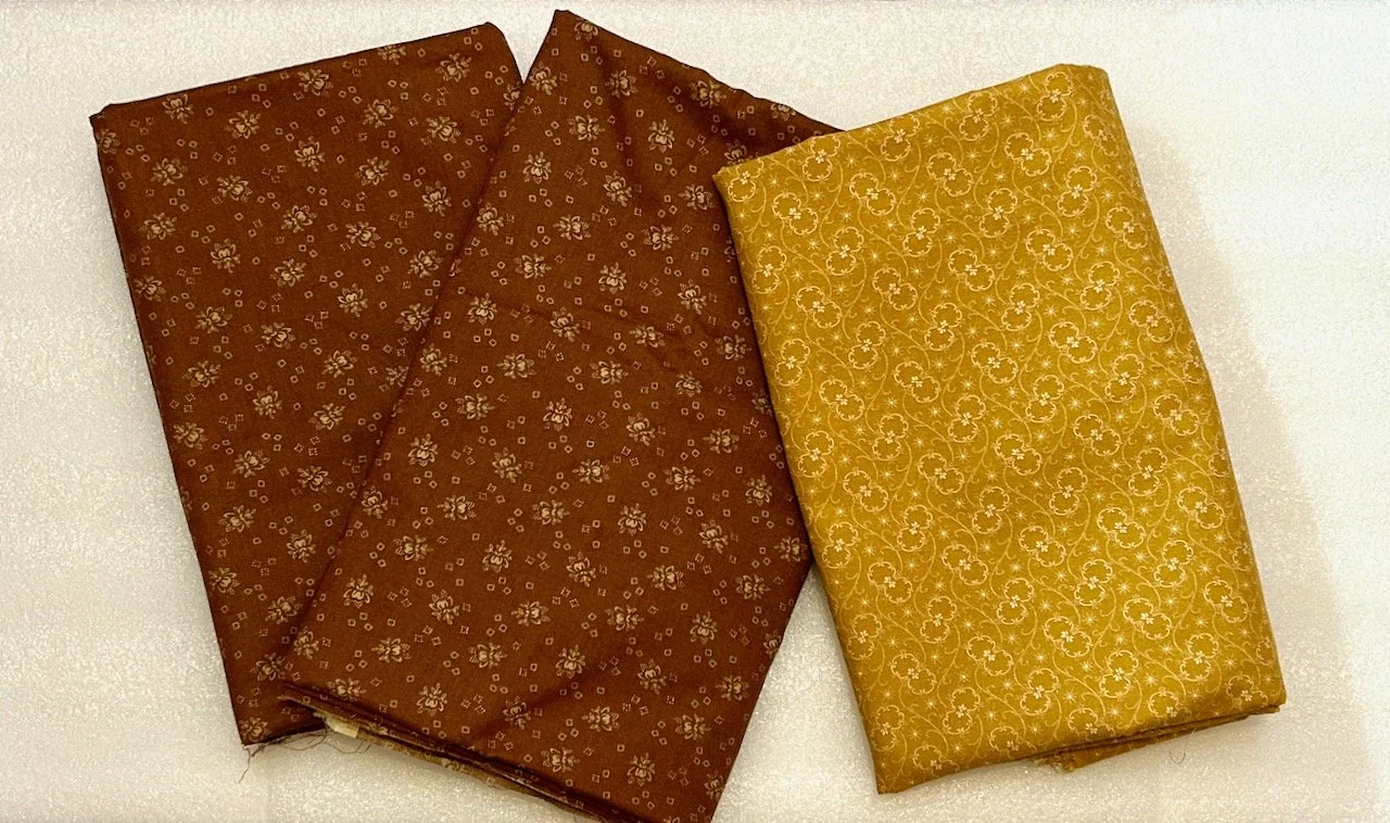 Two browns and a mustard flowery material for the backing, possibly