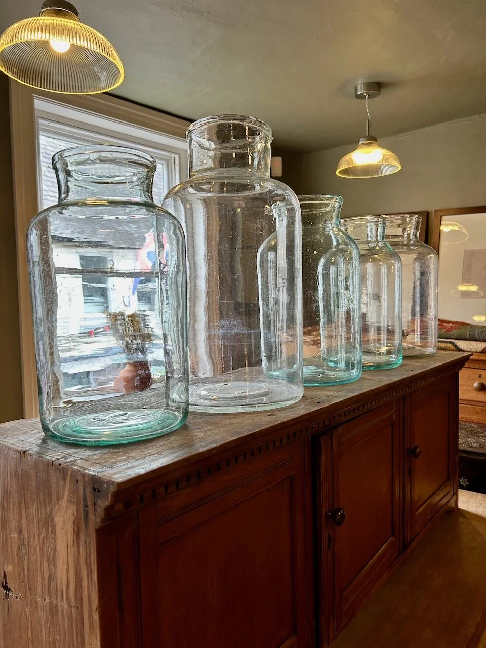 A display of 5 large glass jar/bottles in a Southwell shop