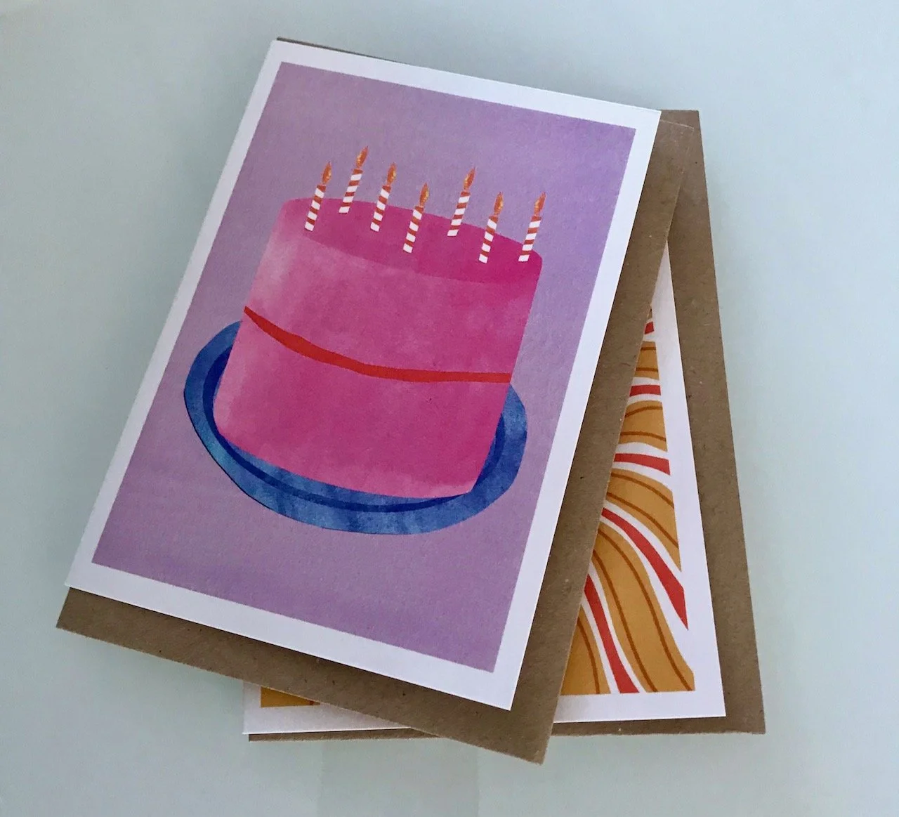 A LARGE PINK BIRTHDAY CAKE WITH CANDLES ON