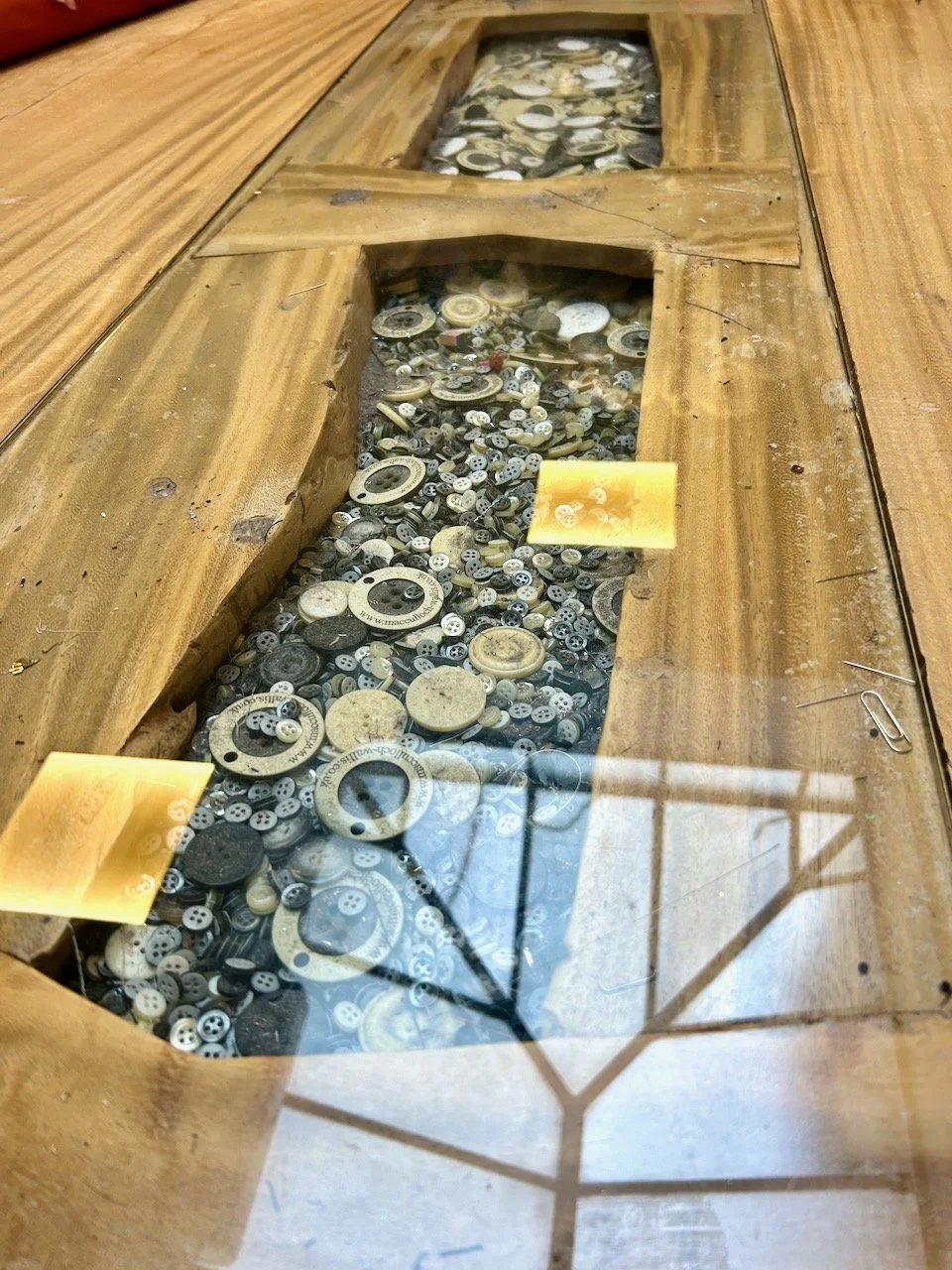 A large wooden cutting table, with a central channel of buttons