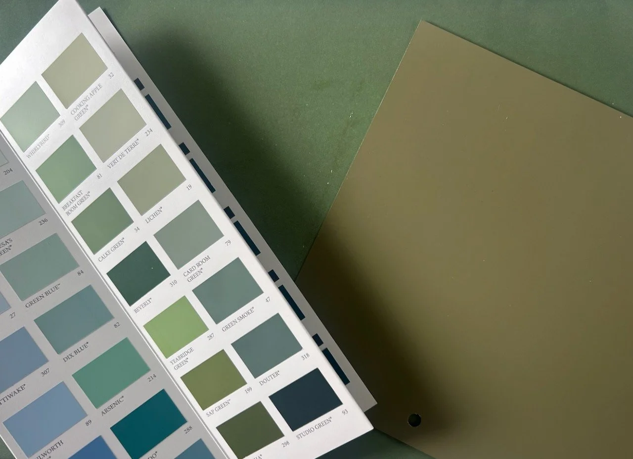 A paint charts of greens along with two larger samples
