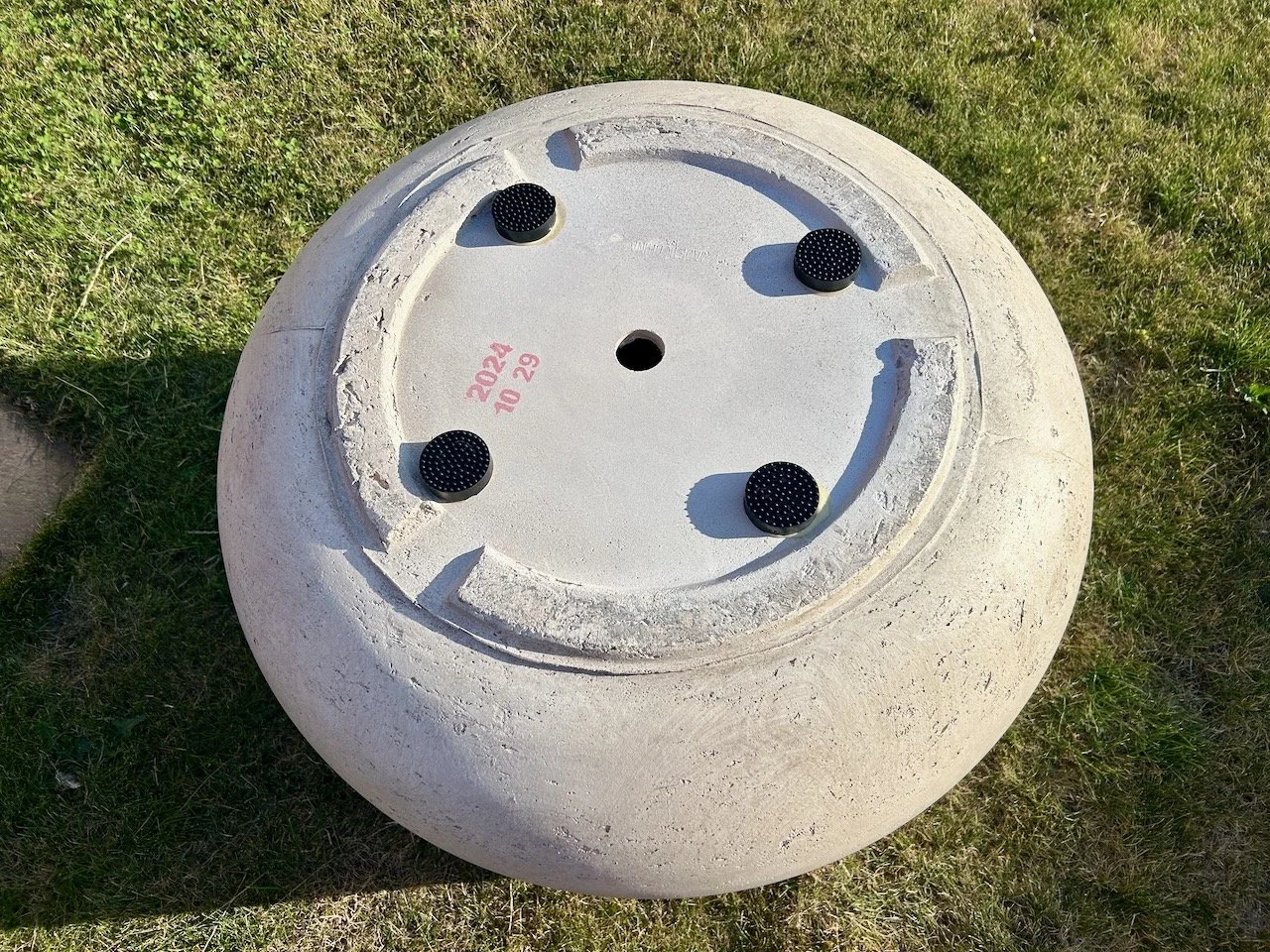 The new large pot upside down with four black pot feet stuck on